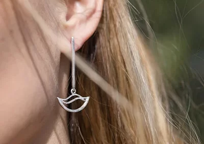 pendiente colgando de una oreja de una chica en un espacio natural, es un primer plano